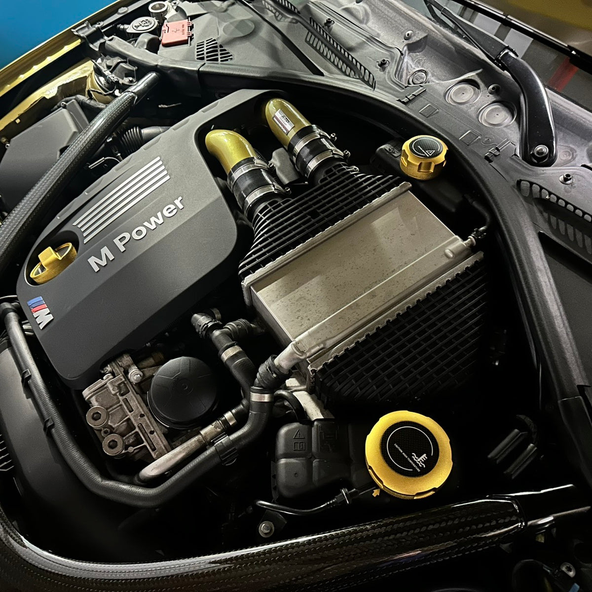 FTP gold MaxCap cover set installed on BMW S55; surrounding vehicle parts not included